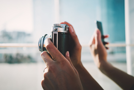 Vintage camera and smart phone on city background Stock Photo