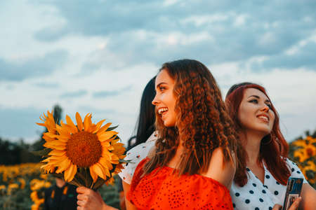 Mujeres jóvenes alegres en un campo de girasoles