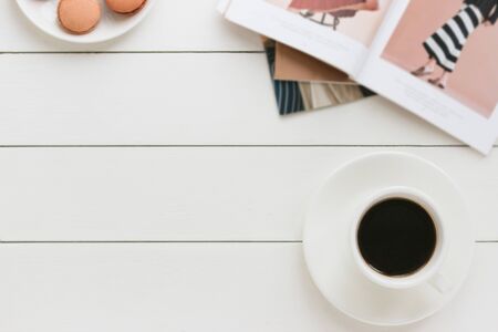 Cup of black coffee on a white wooden table with fashion magazine author processing film effect Stock Photo