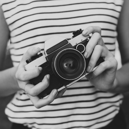 Film camera in the hands of the girl black and white photo