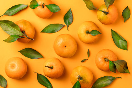 Juicy mandarins with leaves on orange background Stock Photo