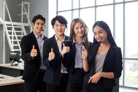 Asia group of call center workers or confident business team with headset in office