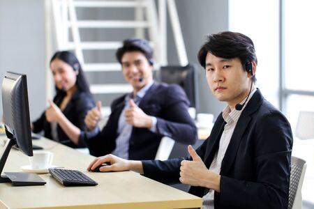 Asia group of call center workers with headset in office