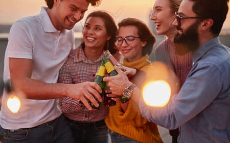 Amigos felices bebiendo cerveza durante la fiesta Foto de archivo