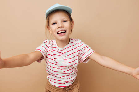 linda chica con gorras azules camiseta a rayas emociones fondo aislado Foto de archivo