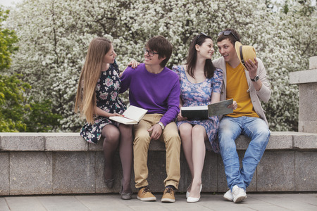 Four friends in the park with books discussing new ideas