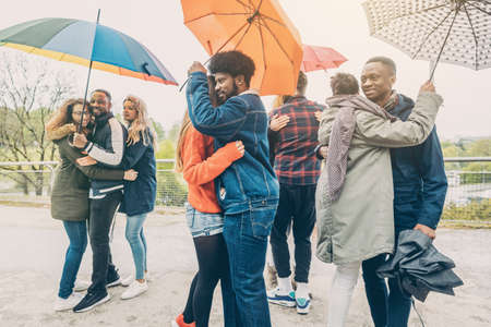 Dancers in the park in rainy weather with umbrellas Stock Photo