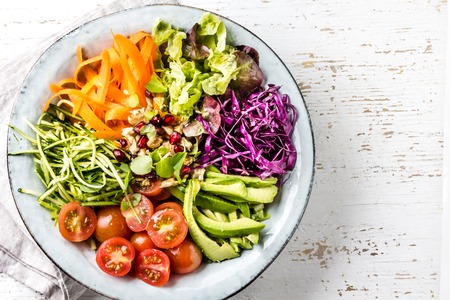 Buddha bowl vegetables nuts salad on white background