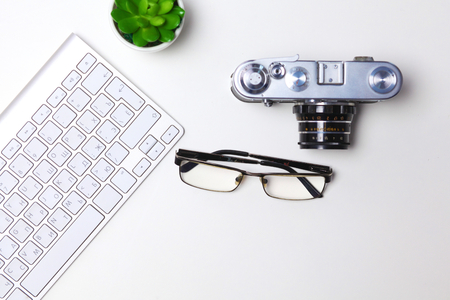 Top view of office graphic design pen mouse with laptop wireless mouse and vintage old camera on white table concept graphic design workplace