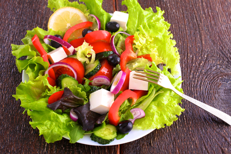 Salad from fresh vegetables in a plate on a table selective focus