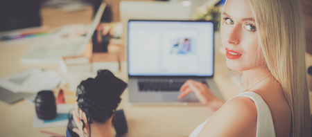 Fashion designers working in studio sitting on the desk Stock Photo