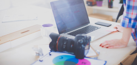 Female photographer sitting on the desk with laptop female photographer