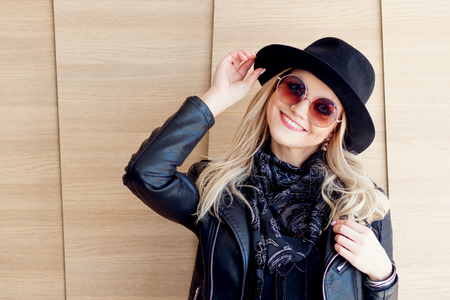 Funny and beautiful blonde in sun glasses and a hat trendy girl portrait outdoor laughs and holds hat