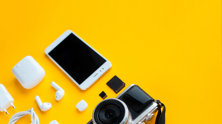 Set for blogger content maker or traveler mirrorless camera smartphone and accessories yellow background