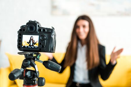 Selective focus of digital camera with happy girl gesturing on screen