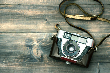 Vintage camera on wooden top view retro style toned picture