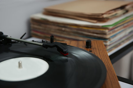 Stylish turntable with vinyl record on table closeup