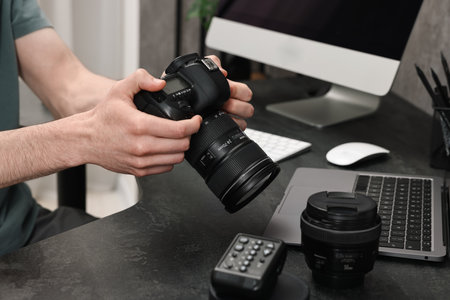 Photographer holding camera at dark table closeup