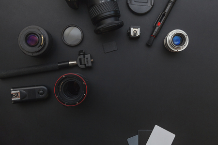 Photographer workplace with dslr camera system camera cleaning kit lens and camera accessory on dark black table background hobby travel photography concept flat lay top view copy space Stock Photo
