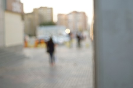 People walking on street in the evening intentionally blurred and film grain effect added