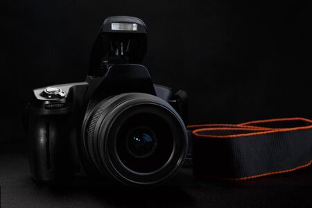 Professional digital slr camera with opened built in flash on black background Stock Photo