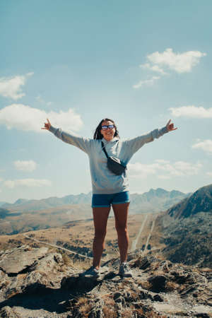 Chica feliz de 20 años en la cima de una montaña en Andorra.
