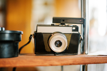 Old camera with on camera flash located on the shelf