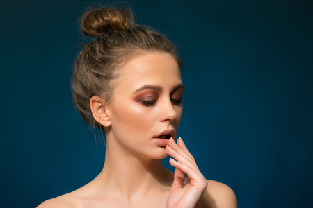 Portrait of beautiful cheerful young woman on blue background