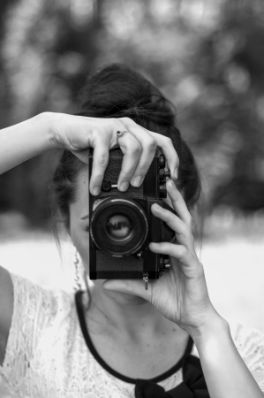 Brunette girl taking shots with retro camera