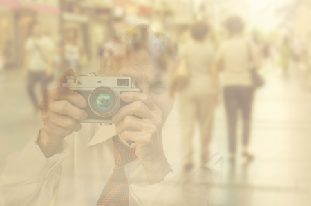 Elderly woman with camera double exposure image with unrecognizable people walking on street