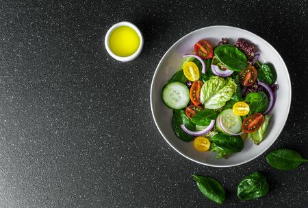 Top view of greens vegetable salad bowl with lettuce spinach and tomatoes Stock Photo