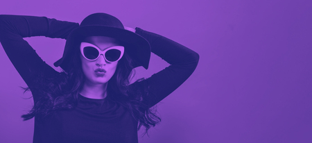 Fashionable woman in sunglasses on a pink background with duotone