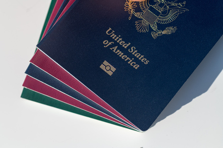 Pasaporte estadounidense azul oscuro junto con pasaportes rojos y verdes estilo UE Foto de archivo