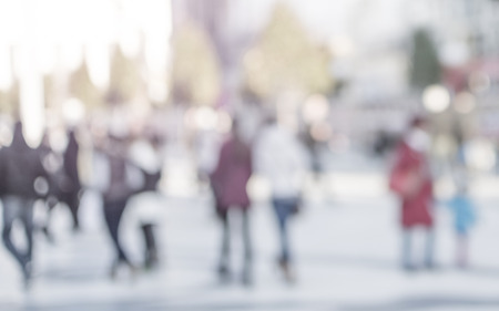 High key blurred image of people walking in the street unrecognizable faces