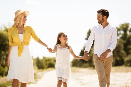 Paseo familiar. Familia feliz descansando en el campo y divirtiéndose, hablando y riendo