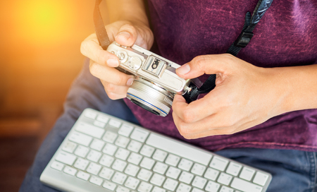 Young male photographer hand hold camera at workplace Stock Photo