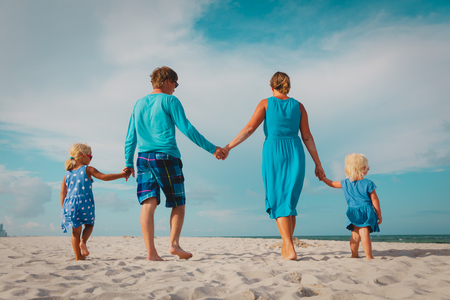 familia feliz con niños caminando en la playa Foto de archivo