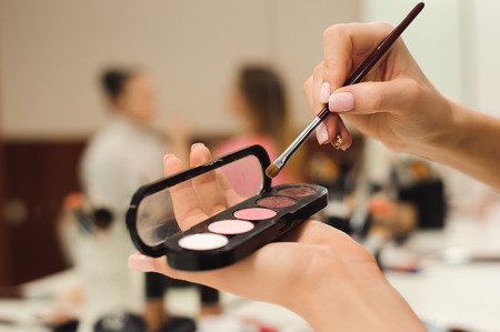 Makeup brush products in hands closeup photo