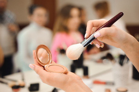 Professional makeup brush in hands of stylist