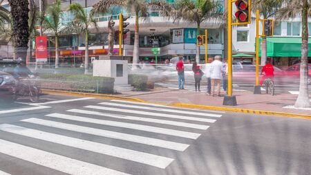 Paso de cebra cerca de la intersección de carreteras principales en la Plaza Grau con timelapse de tráfico en Lima. Centro comercial sobre un fondo