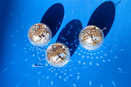 Disco balls decotations on classic blue background with light beams