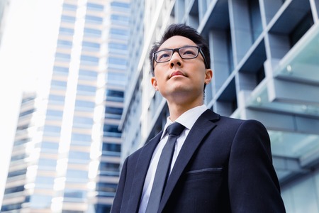 Businessman standing outdoors in city business district Stock Photo