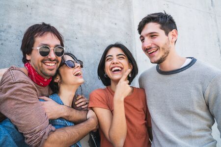 Retrato de un grupo joven de amigos pasando un buen rato juntos y divirtiéndose al aire libre. Concepto de estilo de vida y amistad. Foto de archivo