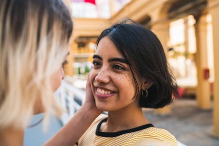 Retrato de feliz pareja lesbiana pasando tiempo juntos y abrazándose en la calle. concepto LGBT.