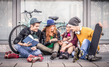 Multi ethnic group of students stdying together outdoors in a college campus