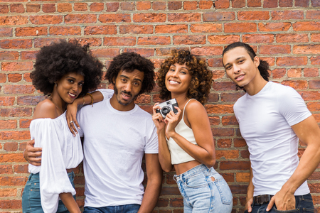 Grupo de amigos afroamericanos que se unen en Manhattan, Nueva York: adultos jóvenes que se divierten al aire libre, conceptos sobre el estilo de vida y la generación de adultos jóvenes