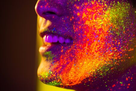 Portrait of fashionable man with colored fluo painting on the face fashion model on colored background Stock Photo