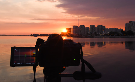 Photography camera while taking the beautiful cloudy sunset scene