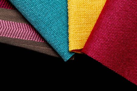 Pieces of cloth of different colors on a black table Stock Photo