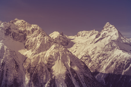 Steep peaks of the caucasus mountains toned image in purple color Фото со стока